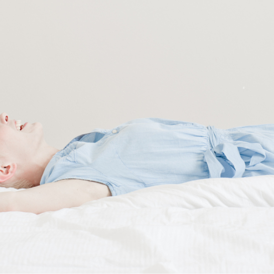Frau liegt im Bett ausgestreckt - ohne Hüftschmerzen